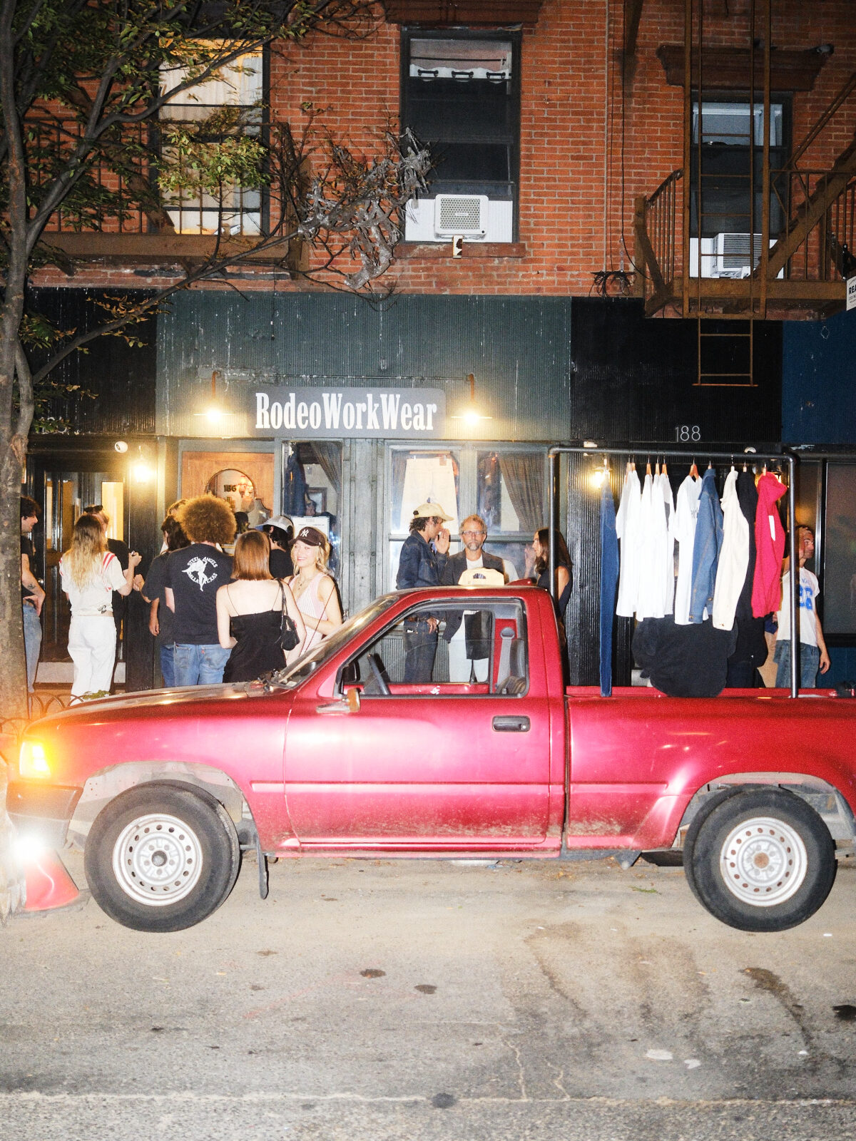 Red pickup truck parked outside the RodeoWorkWear storefront during an event