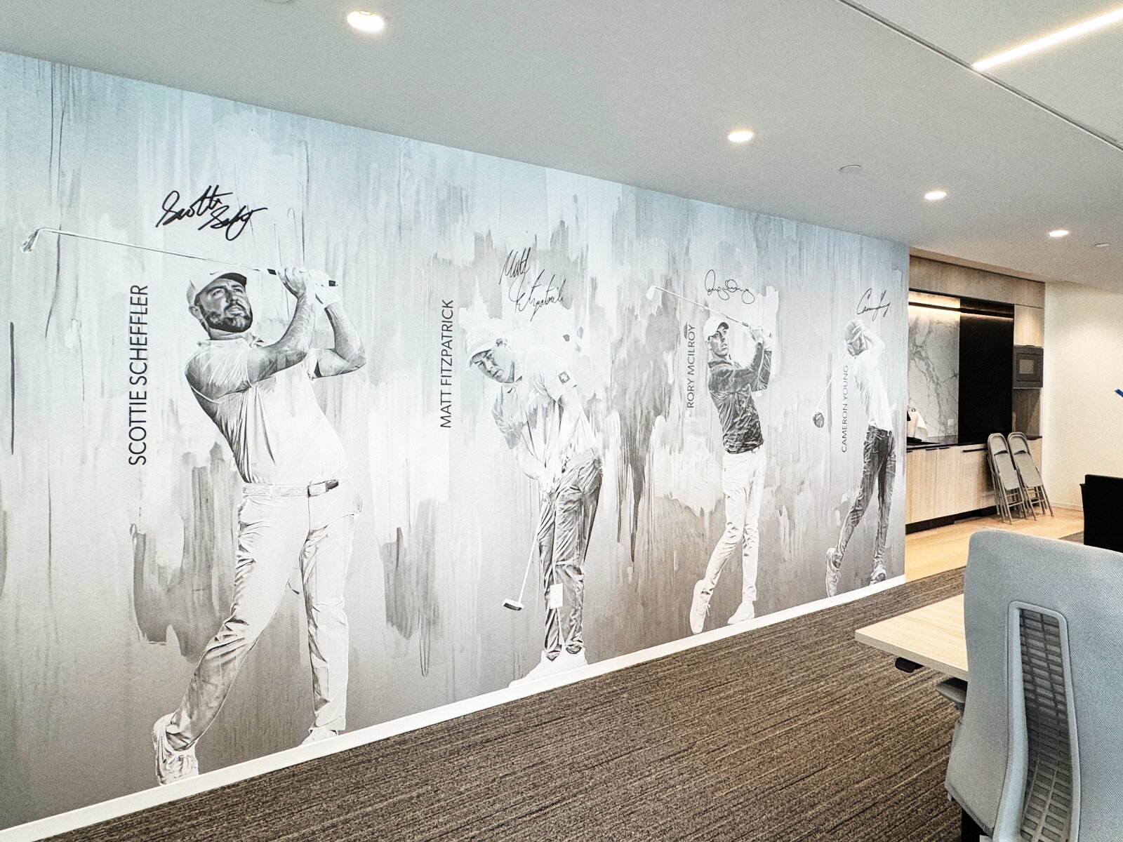 Large-format wallcovering mural of professional golfers with signatures in a corporate office